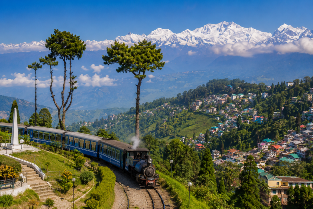 Scenic view of Darjeeling hills, Himalayan mountains, tea gardens, and the famous toy train showcasing the beauty of Darjeeling tourism.